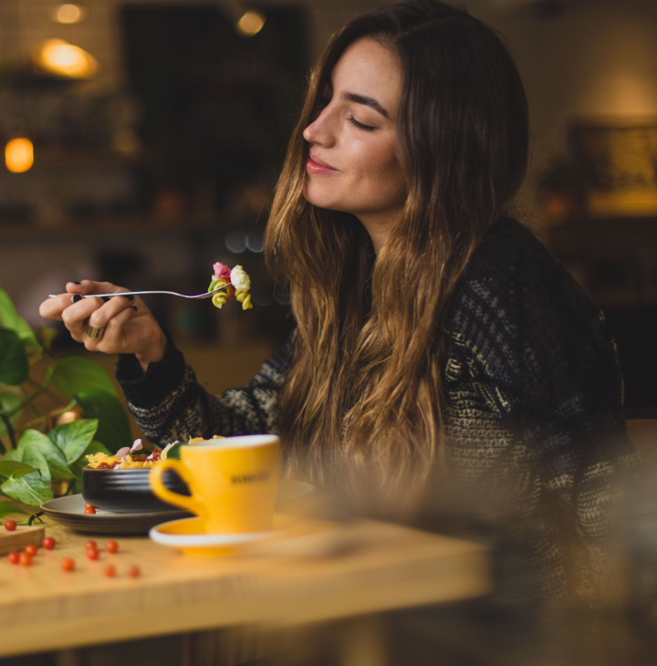 A woman enjoing a bowl of pasta